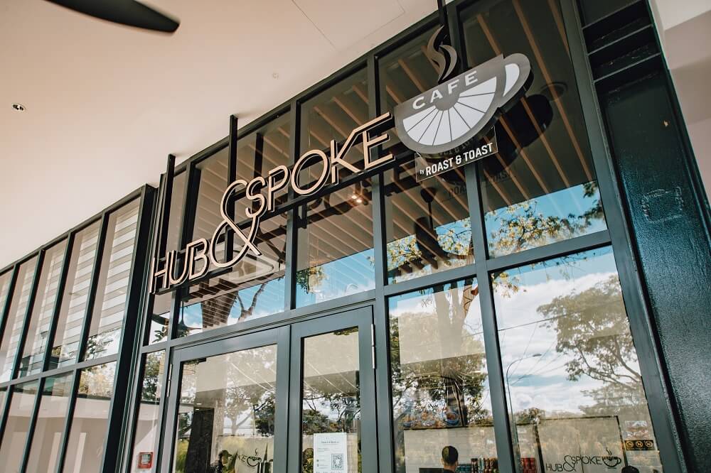 The entrance of Hub & Spoke café with the logo and name prominently displayed.